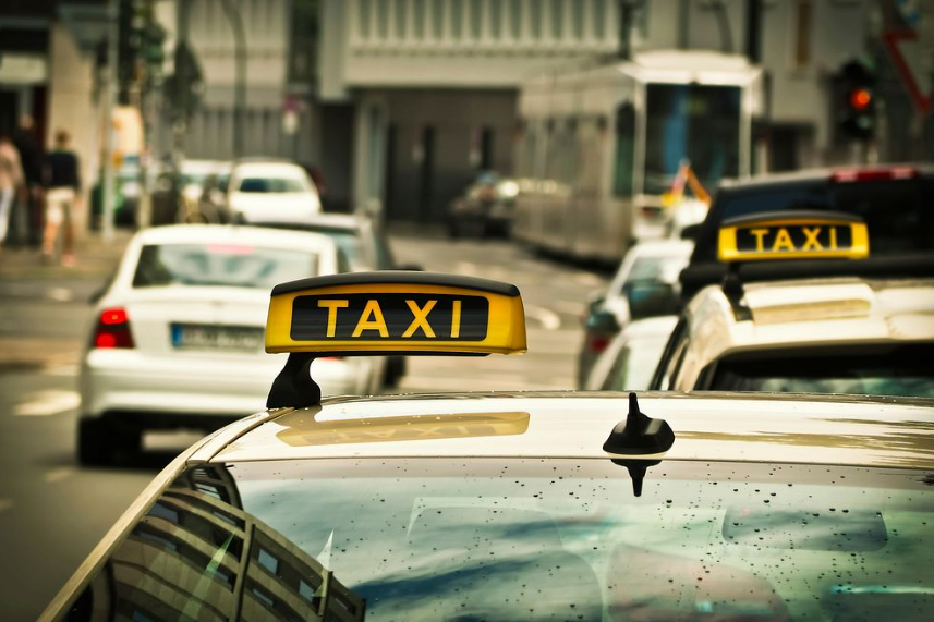 A city scene showcasing a taxi cab's role in airport transfers.